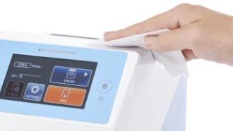 CT4-LX-HC healthcare label printer with a hand cleaning the surface with a disinfectant wipe